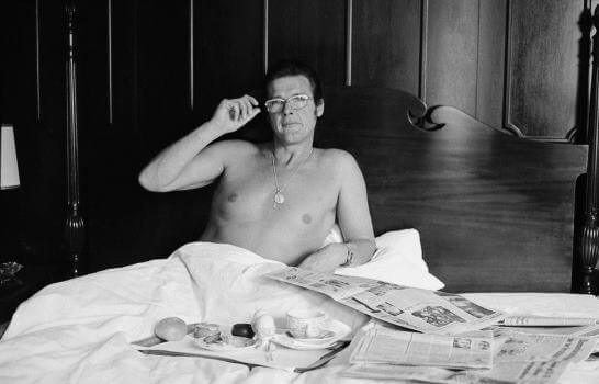 Roger Moore prenant son petit déjeuner au lit